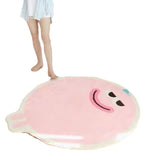 Soft pink blob-shaped smiley face rug on bedroom floor